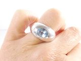 a person holding a ring with a blue stone in it