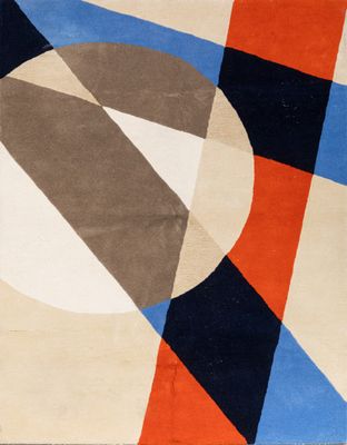 une image représentant un tapis aux motifs géométriques dans les tons de bleu, d'orange et de noir