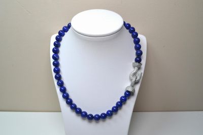 collier composé de perles bleues et muni d'un fermoir en argent, porté par un mannequin blanc