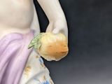 a figurine of a woman holding a piece of bread