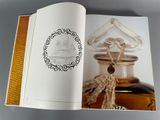 an open book with a picture of a bottle of perfume on it