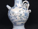 a blue and white vase with a handle on a black background