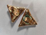 pair of triangle shaped gold earrings with green and gold accents