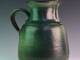 a green vase that is sitting on a table