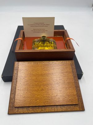 une boîte en bois contenant une bouteille en verre et une carte de visite