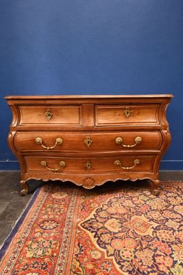 an antique chest of drawers on a rug in front of a blue wall