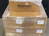 Des cartons de Rebiann sont empilés sur une palette devant un mur noir