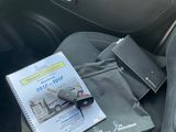 un livre posé sur le siège d'une voiture, à côté d'un sac