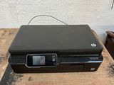 an hp printer sitting on top of a wooden table next to a white wall