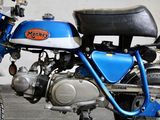 a blue and black motorcycle parked in front of a white wall