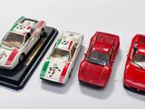 trois petites voitures sont alignées sur une surface blanche