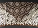 a close up of a brown and white scarf on a table