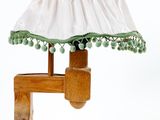 une lampe de table en bois surmontée d'un abat-jour blanc