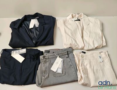 quatre paires de pantalons et une veste posés sur une table
