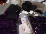 a bottle of water sitting on a bed next to a pile of clothes