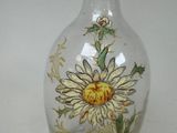 a vase with a flower painted on it on a table