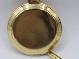 a gold pocket watch with a chain on a white surface