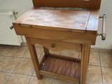 a wooden table with a drawer underneath it on a tiled floor