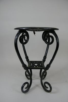 une image représentant une table en fer forgé noir sur fond blanc