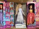 three barbie dolls are in a cardboard box on a table