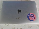 a laptop with a sticker on it sitting on a table