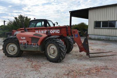 un tracteur rouge garé devant un bâtiment