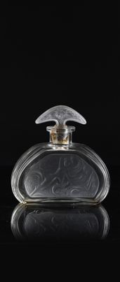 a clear glass perfume bottle sitting on top of a black surface