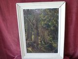 an oil painting of a forest scene in a white frame on a red cloth