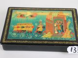 a small box with a painting on it on a table