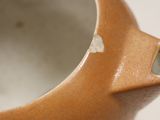 a close up of a brown vase with holes in it