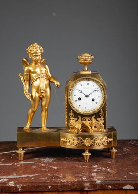 a gold clock sitting on top of a marble table