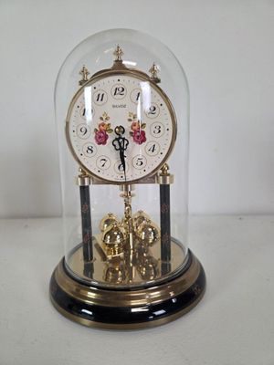 a clock inside of a glass dome on a table