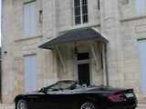 a black car parked in front of a large house