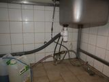 a sink in the corner of a bathroom with a hose attached to it
