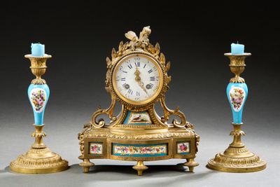 une horloge dorée et trois vases bleus posés sur une table