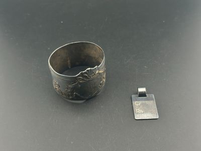 une bague en argent posée à côté d'un petit objet en métal