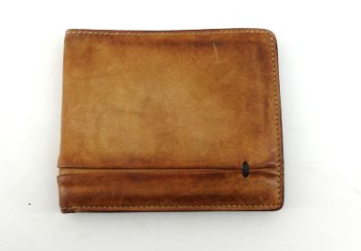 un portefeuille en cuir marron posé sur une table blanche