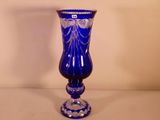 un vase en verre bleu posé sur une table blanche