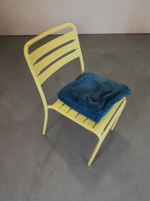 une chaise jaune recouverte d'une couverture bleue