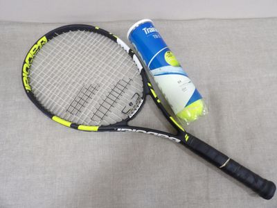 une raquette de tennis et une balle de tennis posées sur un canapé