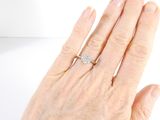 a woman ' s hand with a diamond ring on it