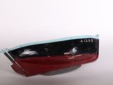 a red and black boat sitting on top of a white surface