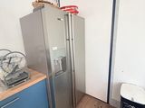 une photo d'une cuisine avec un réfrigérateur et une poubelle