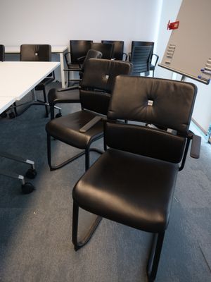 une pièce avec des chaises et une table sur laquelle se trouve un ordinateur portable