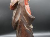 une vieille figurine représentant un homme coiffé d'un chapeau et vêtu d'une robe
