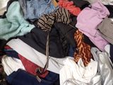 a suitcase full of clothes and clothes on a bed