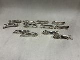 six silver plated dog figurines on a white surface