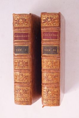 deux vieux livres posés l'un sur l'autre sur une surface blanche