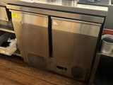 une cuisine en inox équipée d'un évier et d'un réfrigérateur