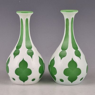 une paire de vases verts et blancs posés sur une table
